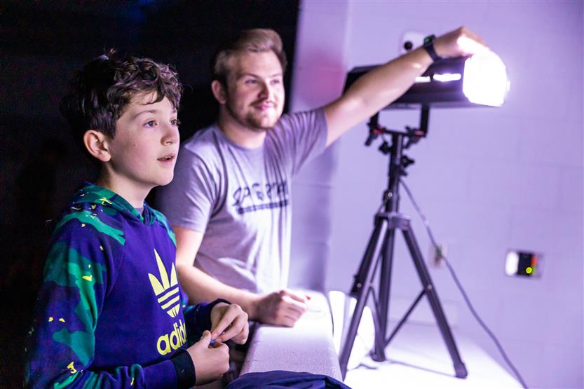 A teacher uses a stage light